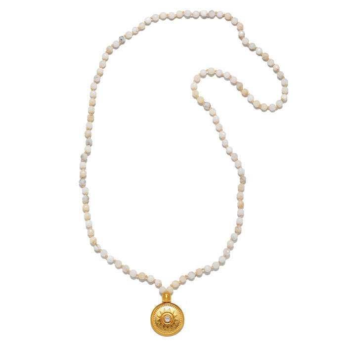 The Tranquil Dawn White Opal Sun Mala laid flat, showing off the elegant arrangement of white opal beads and the golden sun pendant, connecting to themes of spirituality, protection, and meaningful talisman wear.