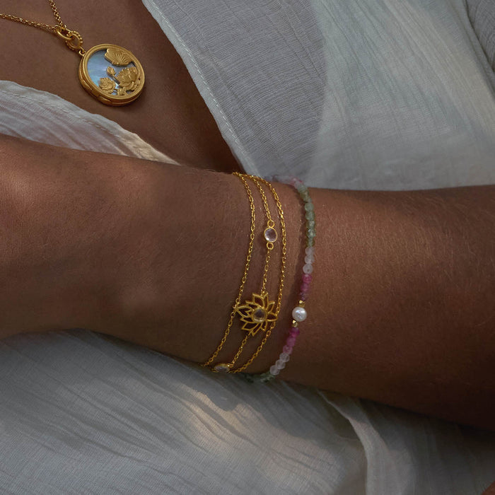 Transformed by Love Lotus Bracelet showcased alongside a pendant, emphasizing its beauty and connection to spiritual meaning. The bracelet embodies love and transformation, making it a perfect talisman for meditation, aiding in manifestation practices and enhancing personal strength.