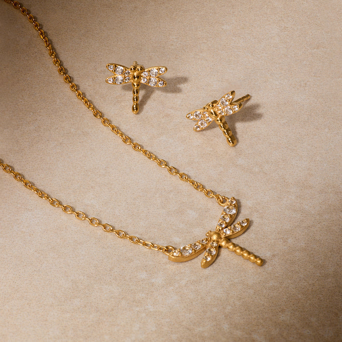 Pair of gold dragonfly earrings with white topaz stones and matching pendant necklace on gold chain.