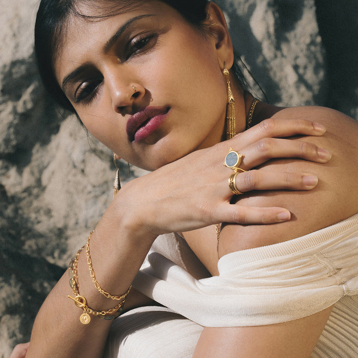 Gold-toned chain bracelet with linked design worn on wrist.