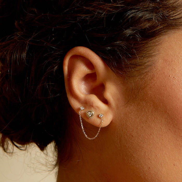 Close-up view of the United by Light 14kt Gold Diamond Chain Earring worn on an ear, highlighting its charm and elegance, representing spiritual meaning and protection, ideal for yoga and zodiac enthusiasts.