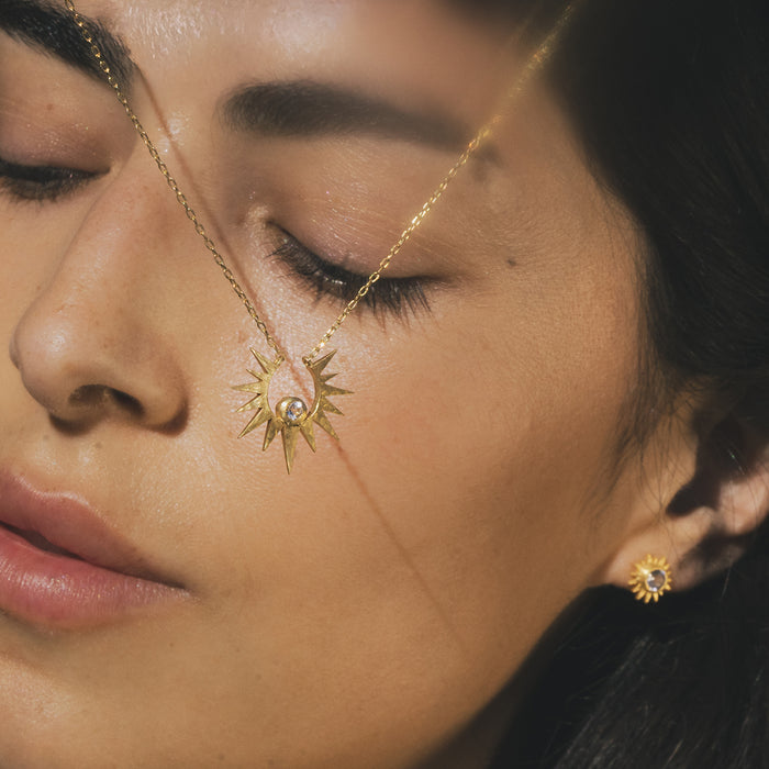 Model wearing the Unveiling Dreams White Topaz Starburst Necklace, showcasing the stunning starburst pendant that evokes the sun's energy. This spiritual jewelry piece embodies protection and intention, making it ideal for those seeking clarity and meaningful connection in their journey.