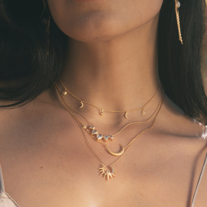 A layered look featuring the Unveiling Dreams White Topaz Starburst Necklace along with other spiritual jewelry, showcasing the beauty of celestial designs, perfect for enhancing meditation practices and personal meaning.