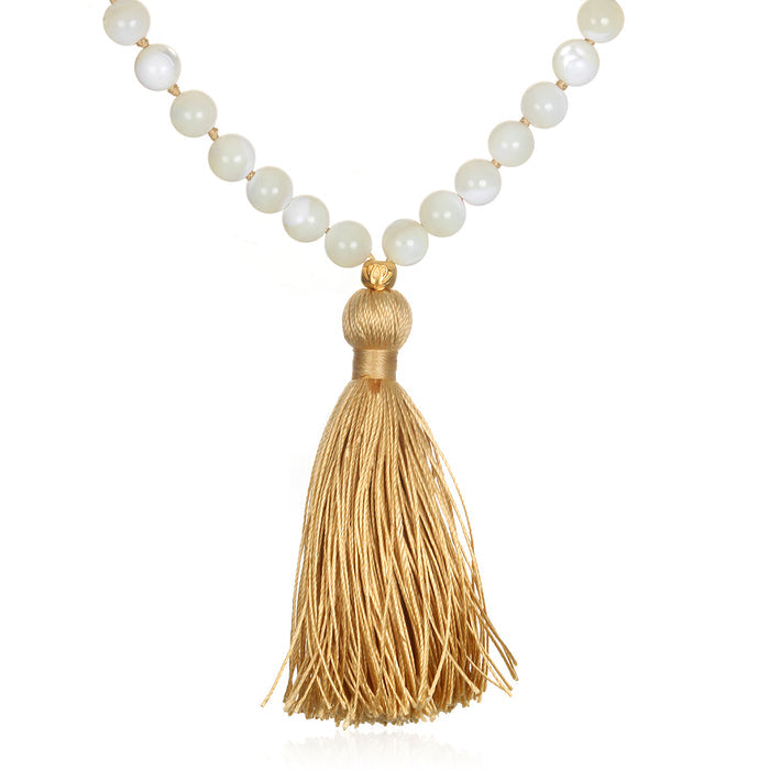 Wisdom Lotus Pearl Gemstone Mala with a golden tassel, perfect for spiritual jewelry and meditation, serving as a talisman for protection and manifestation, symbolizing the sun and moon and enhancing your yoga practice.