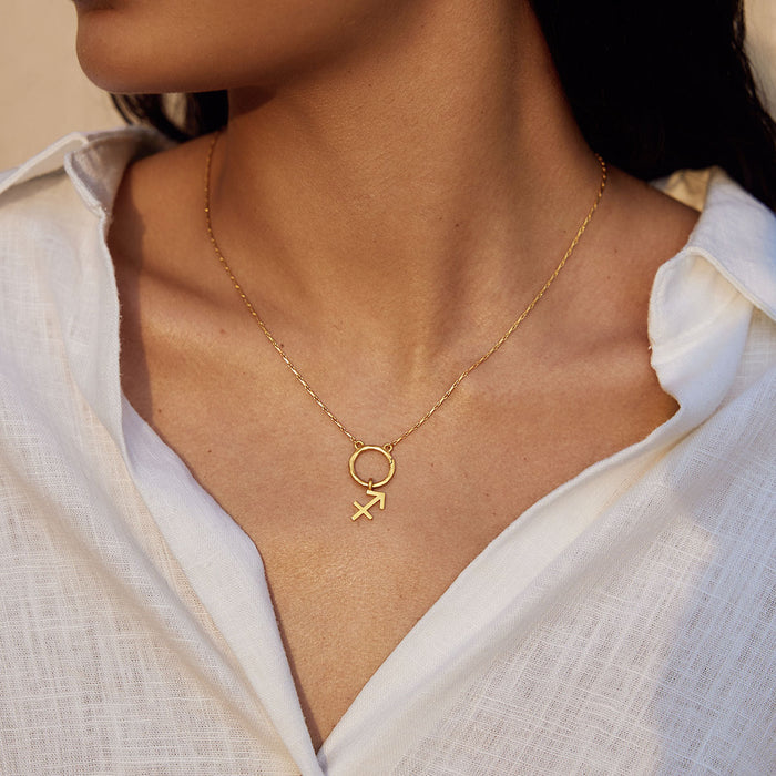 A close-up of a woman adorned with a Zodiac Glyph Charm Sagittarius pendant, showcasing the gold talisman. This meaningful spiritual jewelry piece represents the Sagittarius sign, perfect for protection and meditation during yoga.