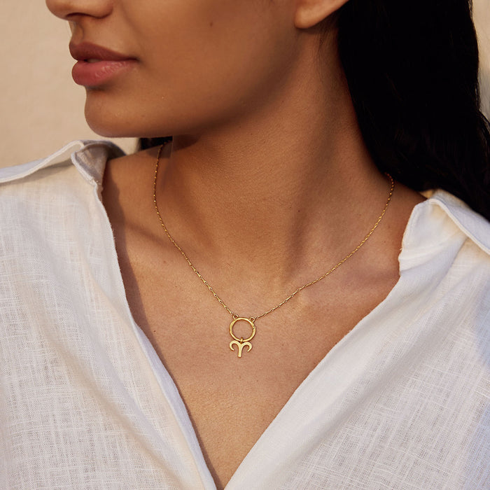 A woman wearing a Zodiac Glyph Charm Aries pendant on her necklace, emphasizing the bold qualities of this zodiac sign. This spiritual jewelry is ideal for manifestation, meditation, and meaningful adornment during yoga sessions.