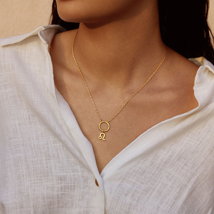 Woman wearing a Zodiac Glyph Charm necklace featuring the Leo symbol, symbolizing spirituality and personal meaning. This spiritual jewelry serves as a talisman for manifestation during meditation and yoga practices.